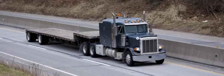 empty step deck trailer on a road
